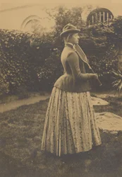 (Frau mit Schläger im Garten)